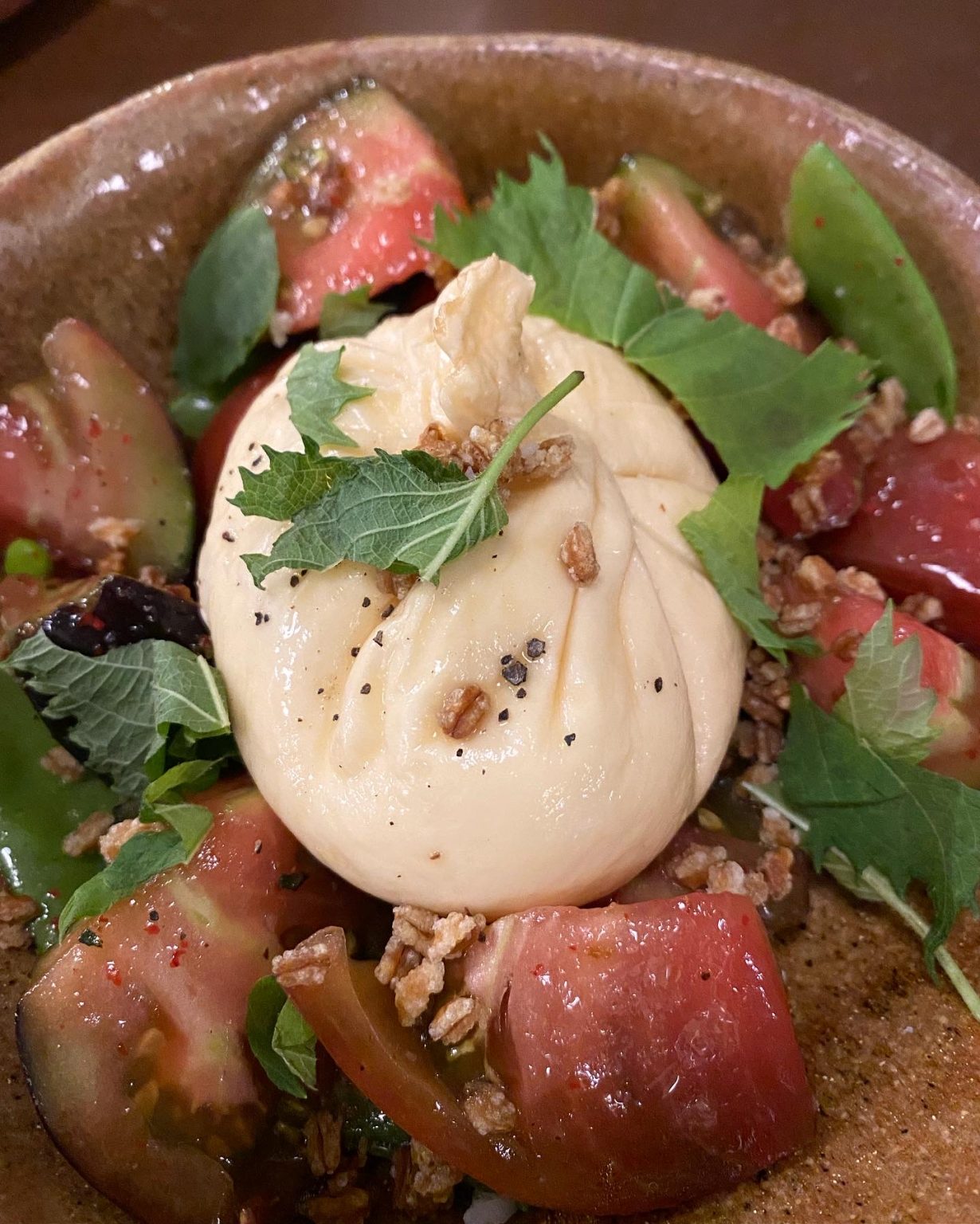 burrata ahumada con jitomate heirloom, shiso, chicharo y farro, sumamente fresca