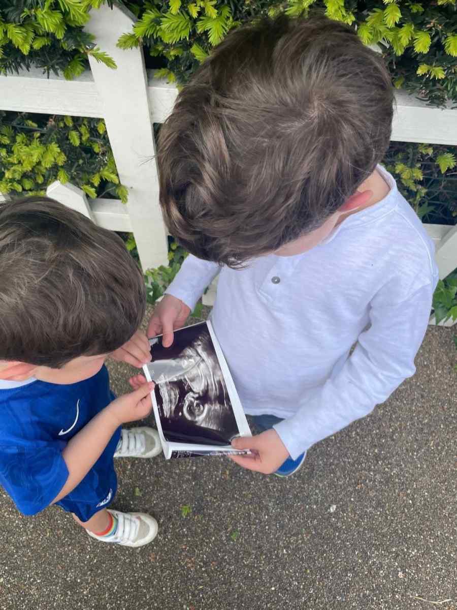 August, de cinco años, y Ernest, de dos, sosteniendo una foto del ultrasonido de su nuevo hermanito.